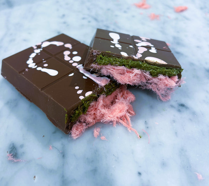 Chocolate bar with pink and green interior on a marble surface