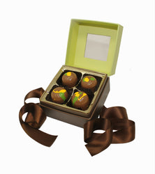 Open box of Dubai chocolate truffles with a brown ribbon on a white background