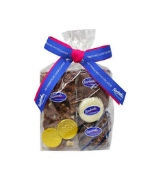 A clear gift bag filled with assorted milk chocolate covered snacks including popcorn, pretzels, Oreos, graham crackers, and chocolate foils, tied with a blue and pink ribbon.